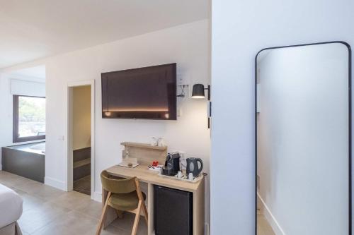 a room with a small table and a tv on the wall at ARTIEM Audax - Adults Only in Cala Galdana
