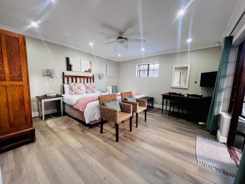a bedroom with a bed and a desk and a piano at Sir Roys Guest House in Port Elizabeth