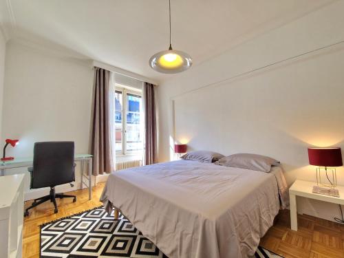 une chambre avec un lit, un bureau et une chaise dans l'établissement Au Coeur de l'Histoire, à Orléans