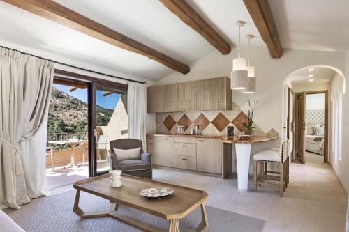 un soggiorno con tavolo e cucina di Relais Villa Carola a Porto Cervo
