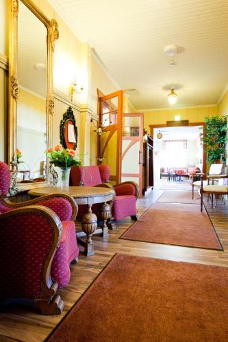 a lobby with chairs and a table and a mirror at Hotelli-Ravintola Alma in Seinäjoki