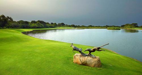 a statue of two birds on a rock next to a lake at Ducks Nest in Malelane