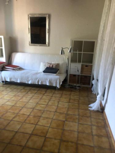 un salon avec un canapé blanc et un sol carrelé dans l'établissement appartement centre ville pleine nature, à Nyons