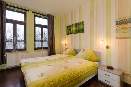a bedroom with a bed and two windows at Stadthaus Waren in Waren