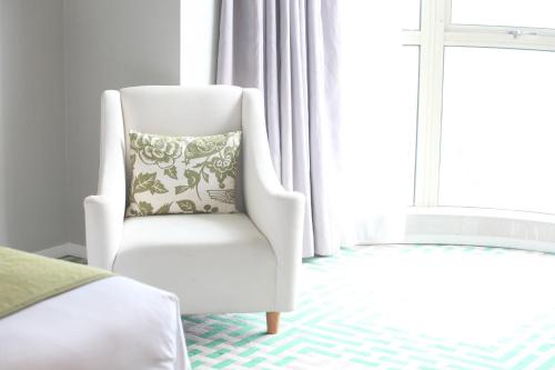a white chair with a pillow in a bedroom at Dorsett Shanghai in Shanghai