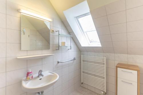a white bathroom with a sink and a window at Strandhaus Malchow in Malchow