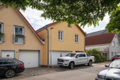 a white truck parked in front of a house at Ostseeoase mit Strandkorb am Meer in Rostock