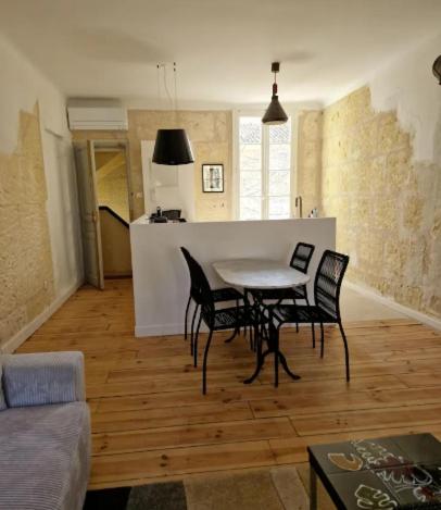 un salon avec une table et des chaises et une cuisine dans l'établissement Appartement avec parking, à Arles