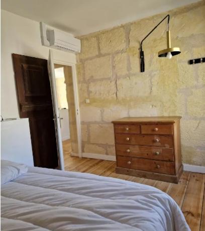 une chambre avec un lit et une commode en bois dans l'établissement Appartement avec parking, à Arles
