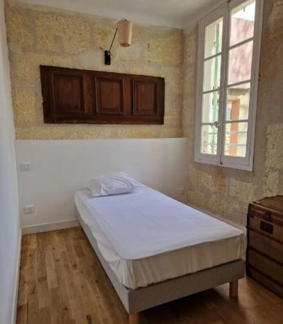 une chambre avec un lit dans une pièce avec une fenêtre dans l'établissement Appartement avec parking, à Arles