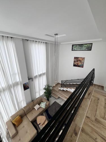 a living room with a couch and a staircase at Prayer Mountain Cove in Kampala