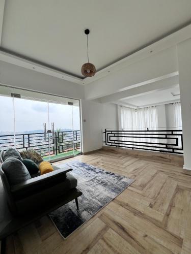 a living room with a couch and a large window at Prayer Mountain Cove in Kampala