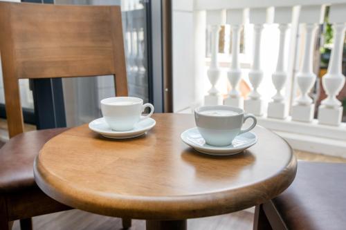 two cups of coffee sitting on a wooden table at Morava Hotel in Istanbul