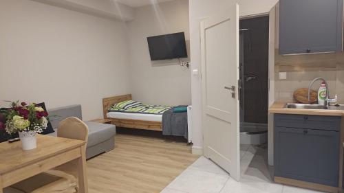 a small apartment with a kitchen and a bedroom at Apartamenty Stara Piekarnia in Sławatycze