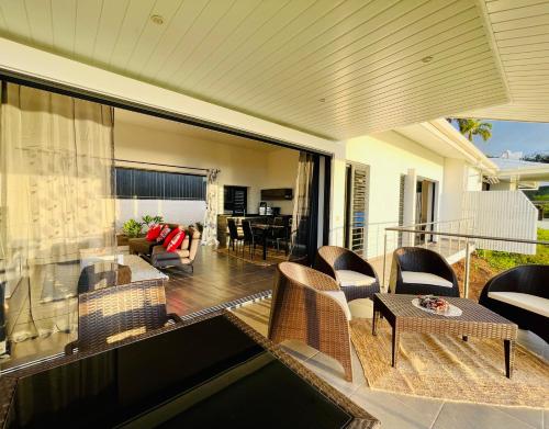 a screened in porch with chairs and a table at Tahiti Moeatama : Villa NUI avec piscine privée in Papeete