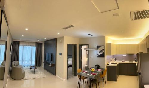 a kitchen and a living room with a table and chairs at Suasana Suites Johor Bahru City Centre in Johor Bahru