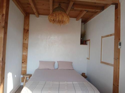 una camera da letto con un letto in una stanza con soffitti in legno di Port et Plage a Carnon-Plage