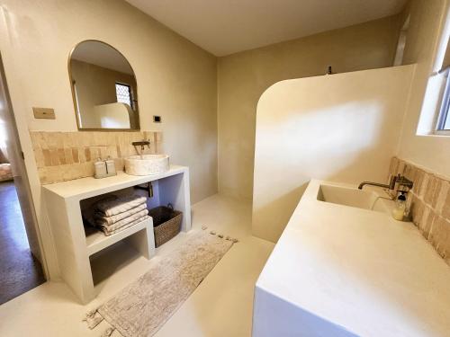un baño con lavabo y espejo en Chic Beachside 2 Bedroom Apartment in Beautiful Coffs Harbour, en Coffs Harbour