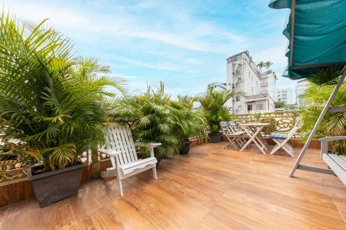 a balcony with a bunch of plants and chairs at Woody House Saigon Center in Ho Chi Minh City