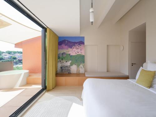 a bedroom with a large white bed and a bath tub at Maison Nova - Boutique Hôtel & Spa in Collioure