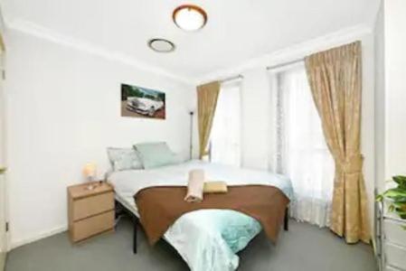 a bedroom with a large bed and a window at Bexley North Entire 2 Storey House 4 or 5 BR 11 Beds 5 mns walk to Train Station and Close to Airport , Sydney CBD in Sydney