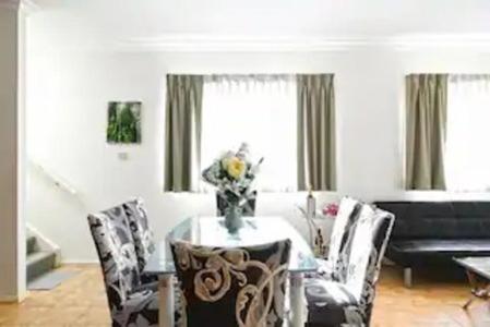 a dining room with a table and chairs and a piano at Bexley North Entire 2 Storey House 4 or 5 BR 11 Beds 5 mns walk to Train Station and Close to Airport , Sydney CBD in Sydney