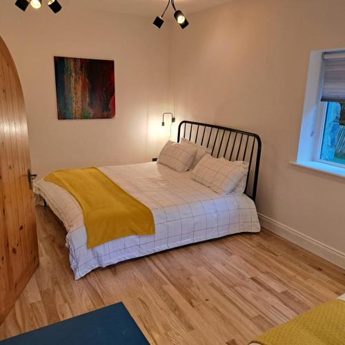 a bedroom with a bed with white sheets and pillows at Knockillaree in Galway