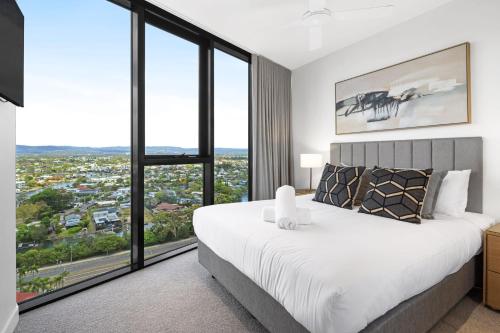 una camera da letto con un letto grande e grandi finestre di CASSA ENCORE - Luxury Apartments Managed by The Cassa a Gold Coast
