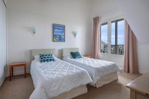 une chambre avec deux lits et une fenêtre dans l'établissement Duplex avec balcon, piscine et accès plage pour 4, au Croisic