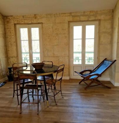 une pièce avec une table, des chaises et des fenêtres dans l'établissement Appartement proche du centre-ville, à Arles