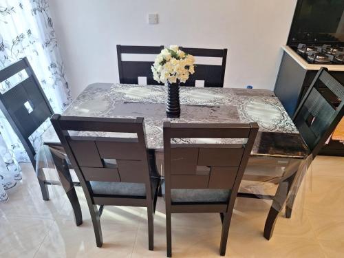 a dining room table with a vase with flowers on it at Royal Villa in Marawila