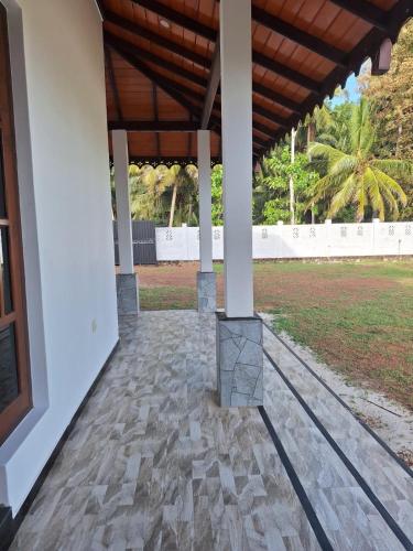 a porch of a house with a wooden roof at Royal Villa in Marawila
