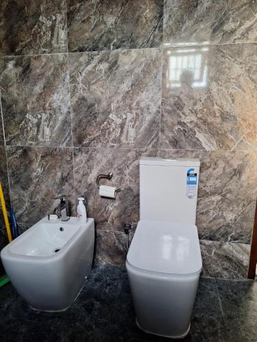 a bathroom with a white toilet and a sink at Royal Villa in Marawila