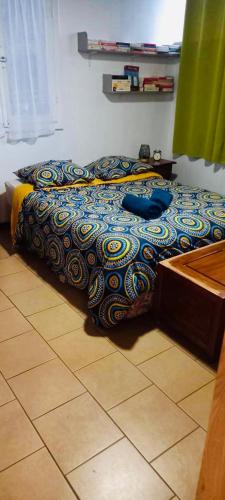 a bed with a colorful comforter in a bedroom at Maison de vacances à Bras-Panon in Bras-Panon