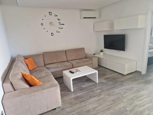 ein Wohnzimmer mit einer Couch und einer Uhr an der Wand in der Unterkunft Novi Lux in Novi Vinodolski