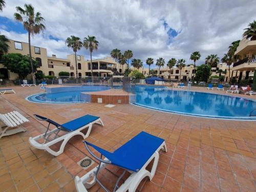 德尔锡伦西奥海岸Paraiso Tagoro Park的游泳池旁的游泳池配有2把躺椅