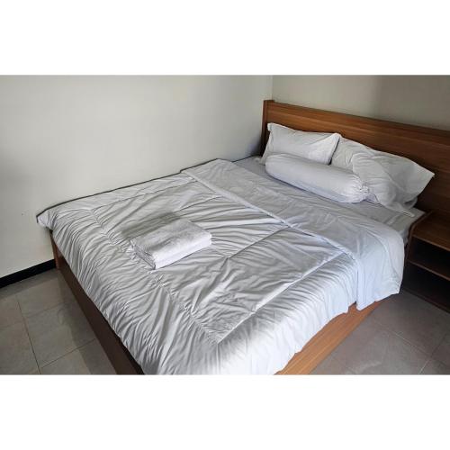 a large bed with white sheets and pillows at Guest House Saqeena Syariah Near Blitar Park RedPartner in Blitar