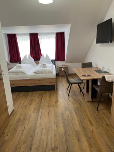 a room with a bed and a desk and a table at Apartments und Zimmervermietung in Liesingthal