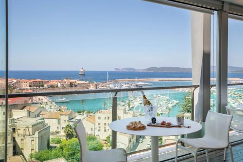 a table and chairs on a balcony with a view of the ocean at Hotel Catalunya in Alghero