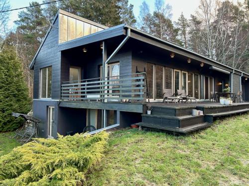 a large house with a porch and a deck at Inn Serendipity Eesti in Jaagupi