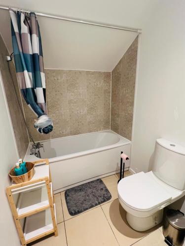 une salle de bain avec une baignoire blanche et des toilettes dans l'établissement Agréable appartement proche de disney, à Chanteloup-en-Brie