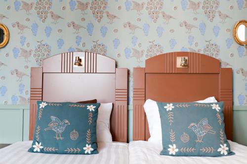 a bedroom with a bed and two pillows at Hotelli-Ravintola Alma in Seinäjoki