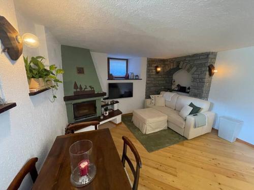 a living room with a table and a living room with a couch at La Bombetta Gialla di Elisa e Marco in Morgex