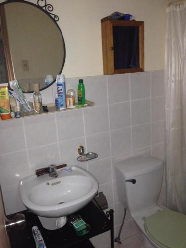 a bathroom with a sink and a toilet and a mirror at Mactan Cebu House in Cebu City