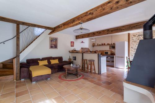 a living room with a couch and a kitchen at Mas Vizern avec bain nordique in Taillet