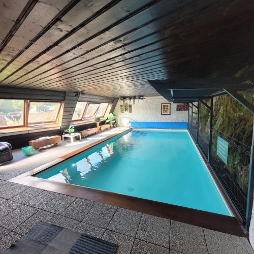 une grande piscine dans un immeuble dans l'établissement villa deloro, à Orbey