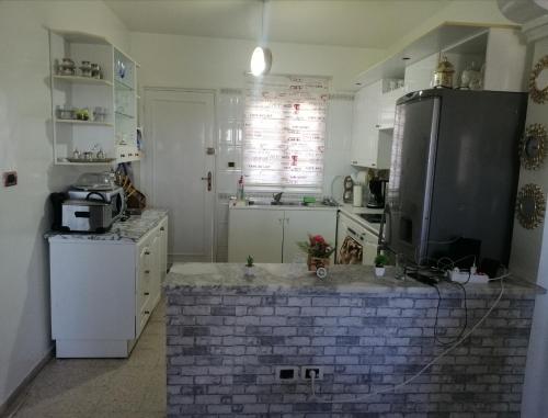 a kitchen with a brick island in the middle at Joli appartement vue sur la mer in Sousse