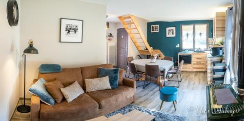 un salon avec un canapé et une table dans l'établissement Charmant chalet La Zaubette au bord de l'eau, à Le Ménil