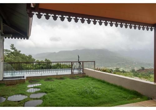 a balcony with a view of a mountain at Malhar Machi Mountain Resorts in Mulshi