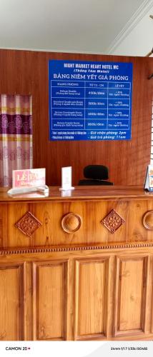 a wooden counter with a blue sign above it at Night Market Heart Hotel MC in Mộc Châu